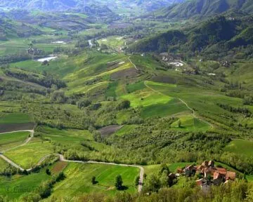 Val Curone con campi verdi e case tra le colline